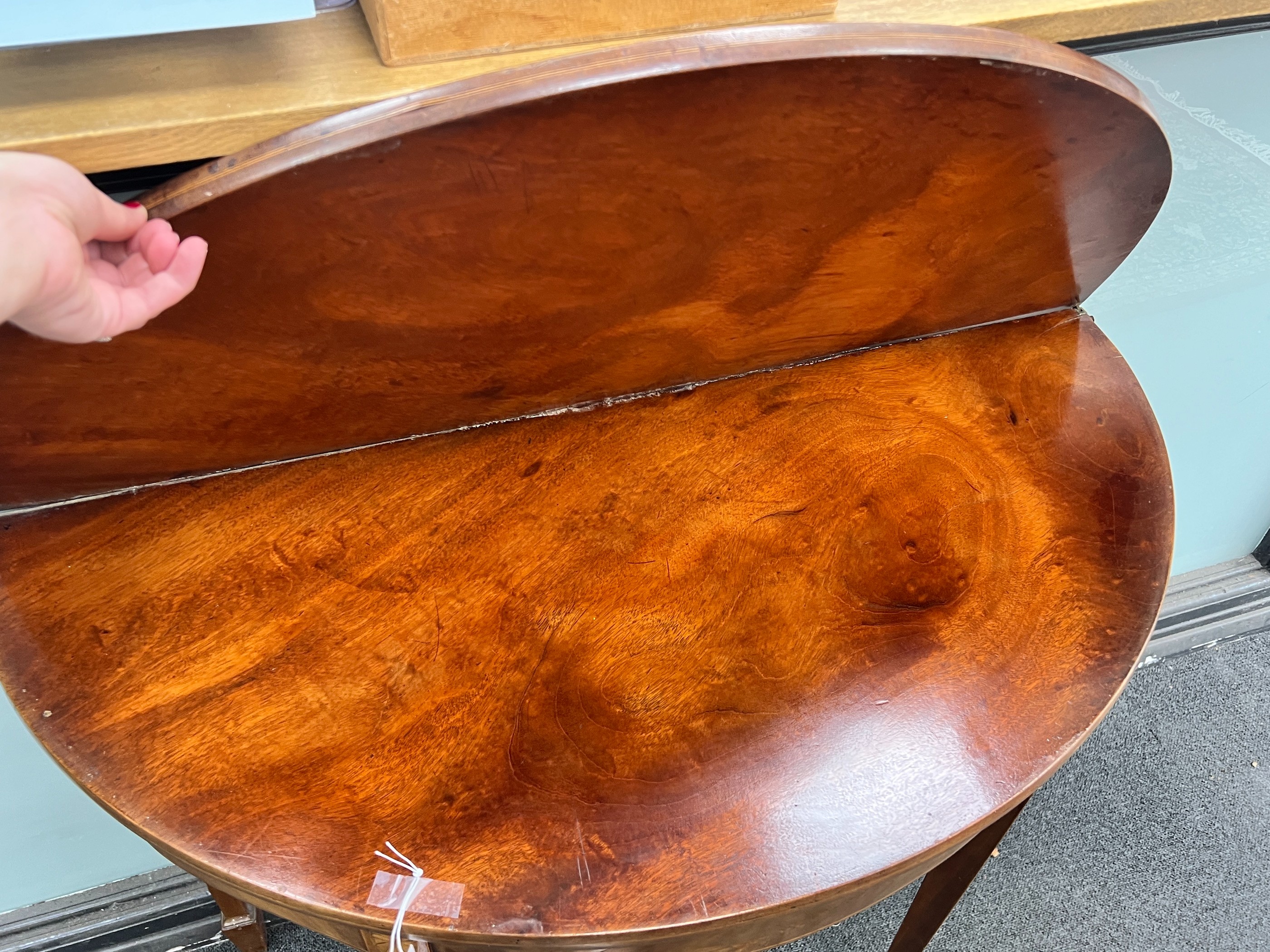 A George III inlaid mahogany demi-lune folding tea table, width 96cm, depth 45cm, height 74cm